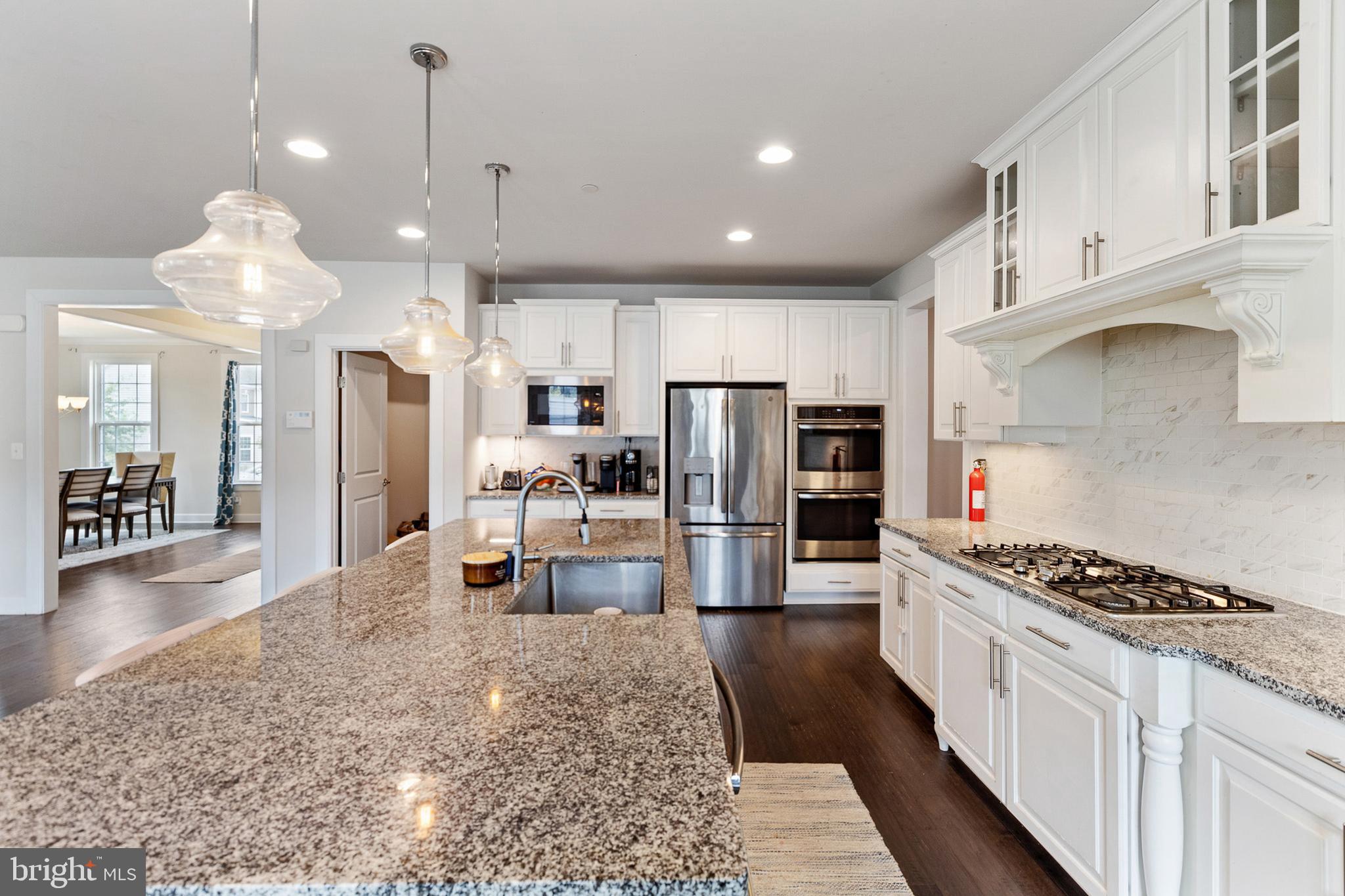 4300 Open Field Court Bowie, MD 20720 - Photo 9 of 53 a kitchen with stainless steel appliances kitchen island a refrigerator and a stove top oven