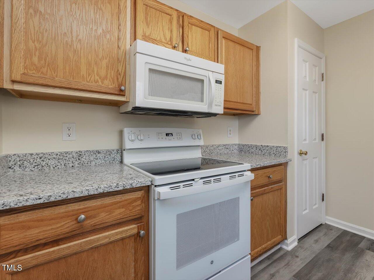 2907 Dearborn Drive Durham, NC 27704 - Photo 20 of 52 a kitchen with stainless steel appliances granite countertop white cabinets and a stove top oven