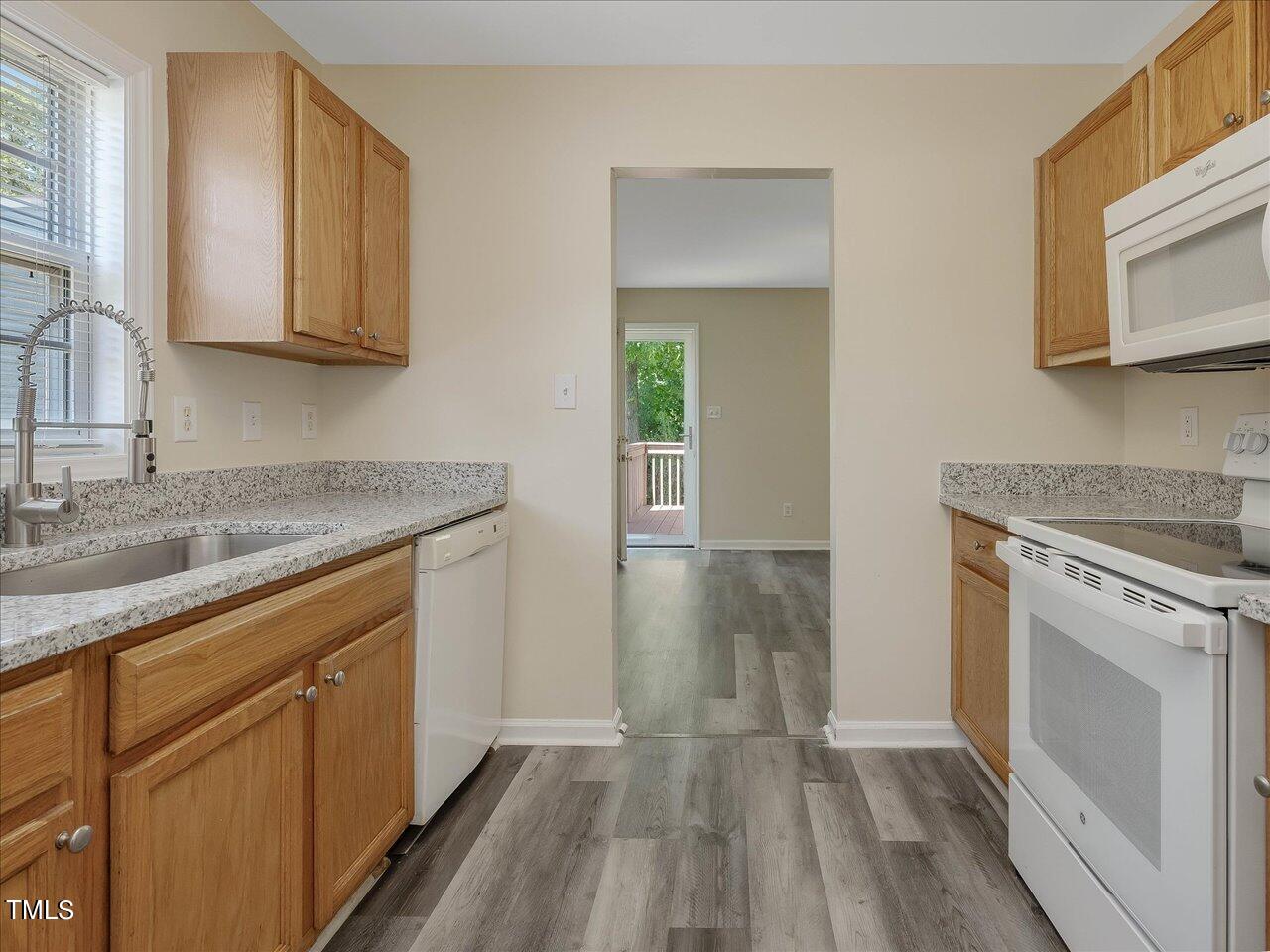 2907 Dearborn Drive Durham, NC 27704 - Photo 22 of 52 a kitchen with wooden floors and white cabinets