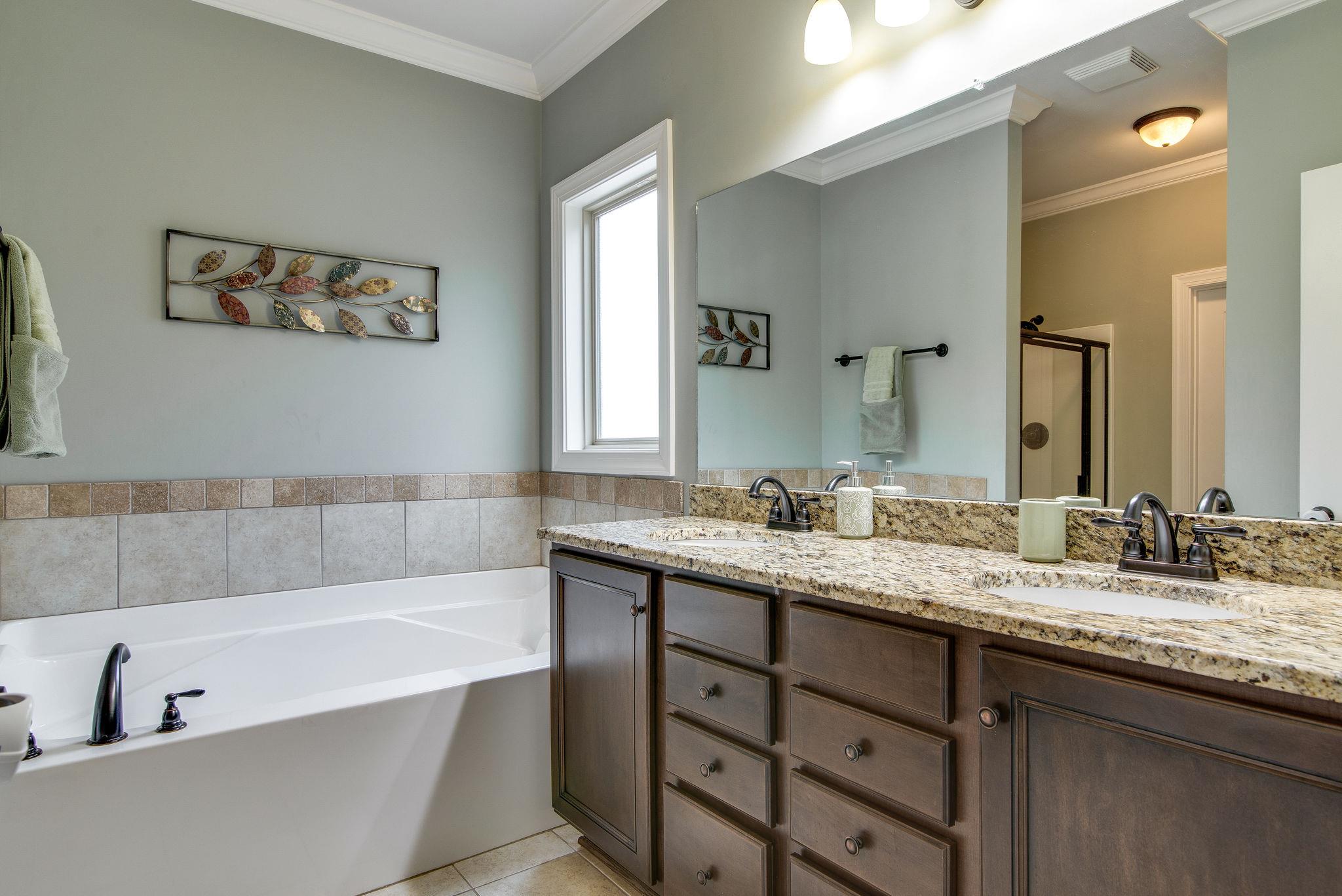 737 Harkreader Road Mount Juliet, TN 37122 - Photo 11 of 26 a bathroom with a tub a double vanity sink and a mirror