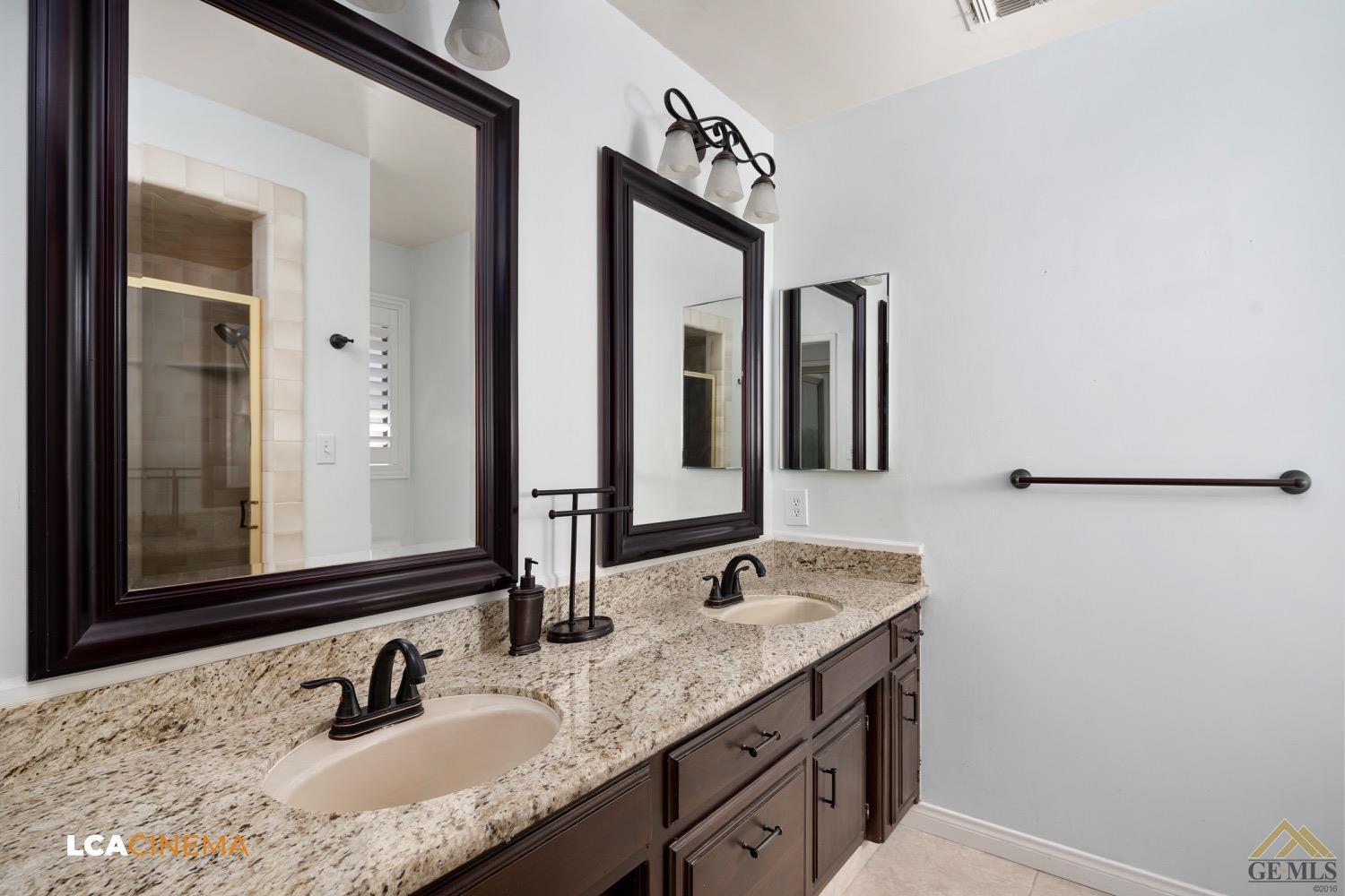 Undisclosed Address Bakersfield, CA 93308 - Photo 18 of 23 a bathroom with a granite countertop sink and a mirror