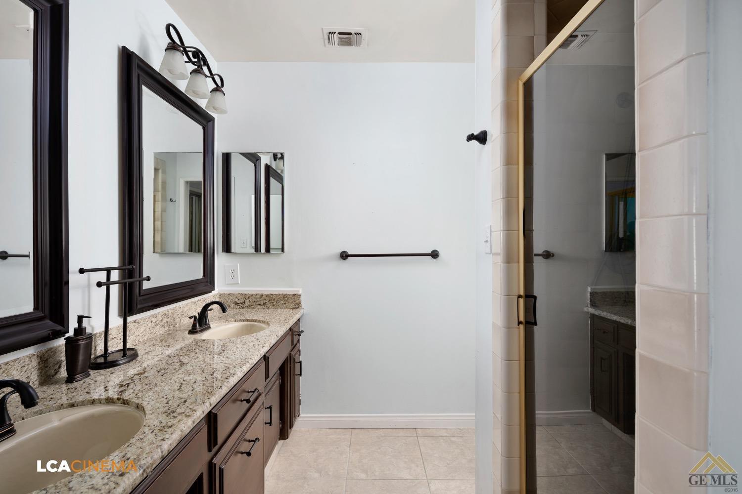 Undisclosed Address Bakersfield, CA 93308 - Photo 19 of 23 a bathroom with a granite countertop sink and a mirror