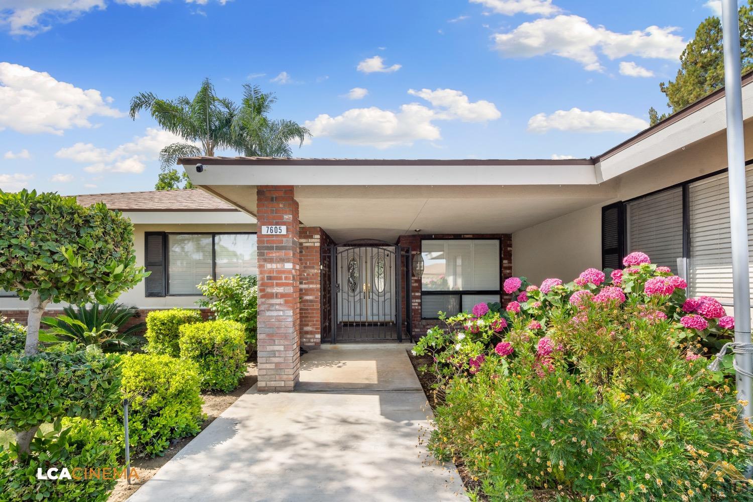 Undisclosed Address Bakersfield, CA 93308 - Photo 4 of 23 a front view of a house with a yard and a fountain
