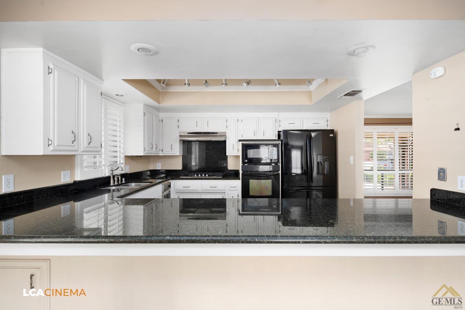 Undisclosed Address Bakersfield, CA 93308 - Photo 10 of 23 a kitchen with stainless steel appliances granite countertop a sink a stove and a microwave