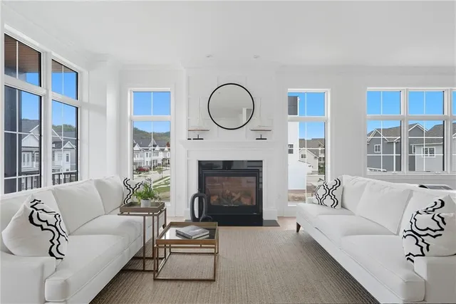 a dining room with furniture a fireplace and large windows