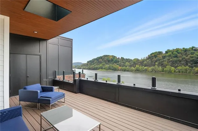 a view of roof deck with couches and wooden floor