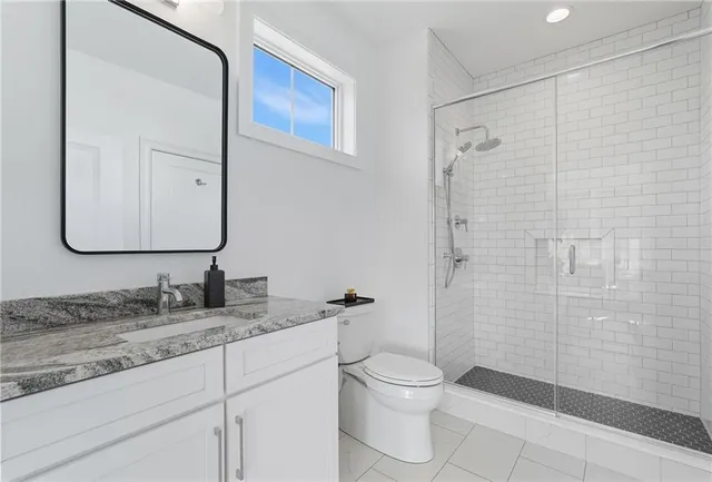 a bathroom with a granite countertop sink toilet and shower