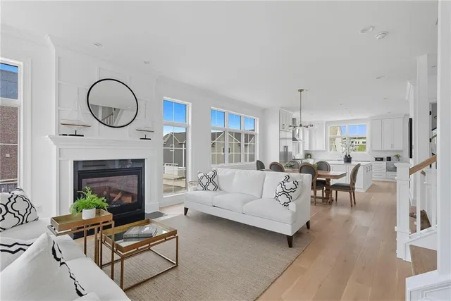 a living room with furniture a fireplace a rug and a large window