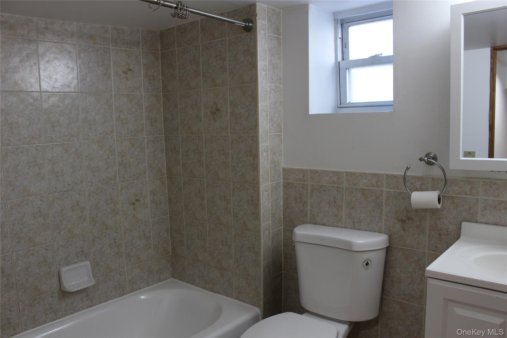 2973 Harding Avenue Bronx, NY 10465 - Photo 15 of 27 Bathroom with vanity, bathing tub / shower combination, and tile walls