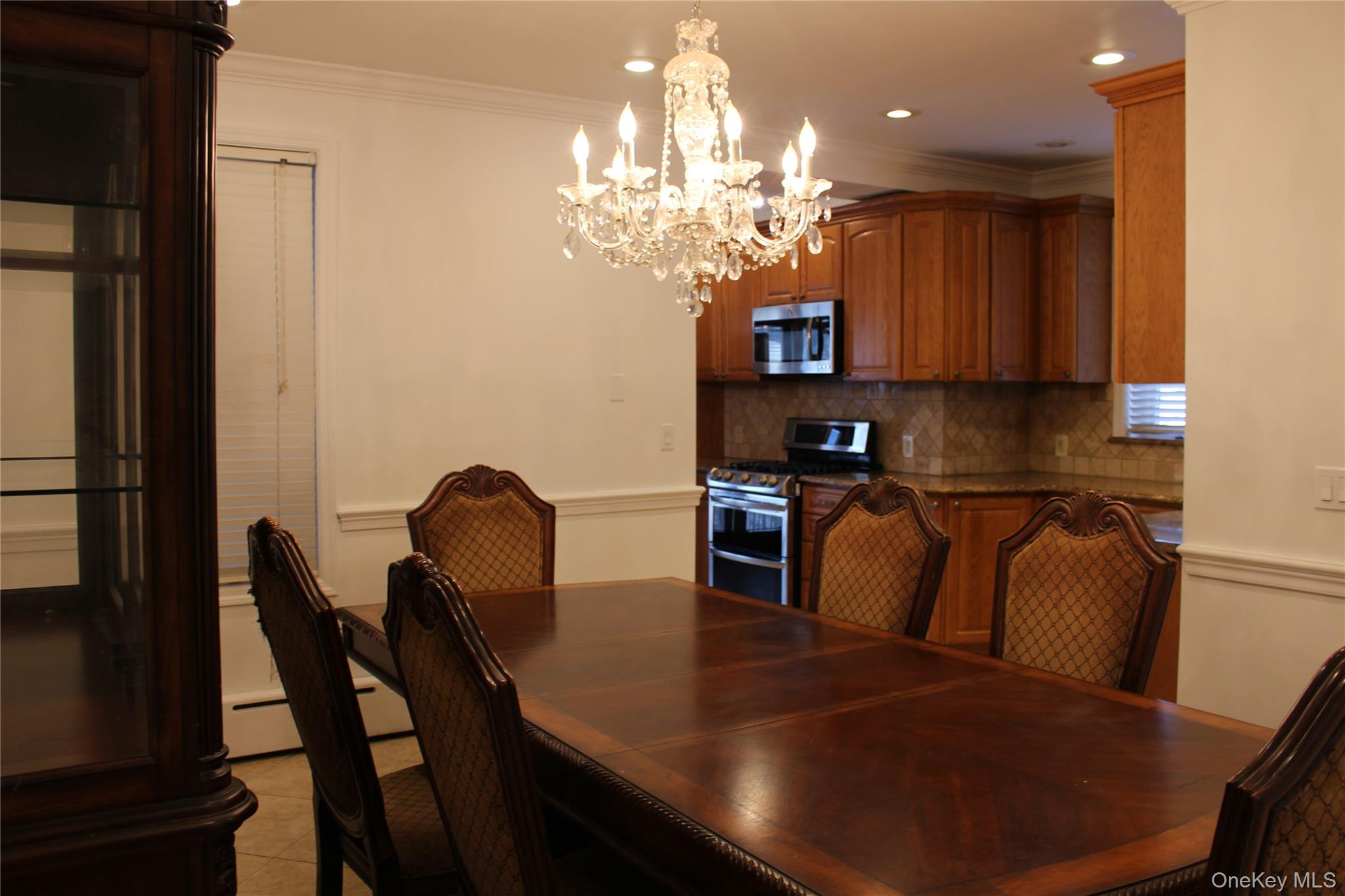 2973 Harding Avenue Bronx, NY 10465 - Photo 7 of 27 Dining area featuring ornamental molding, a wainscoted wall, a chandelier, light tile patterned floors, and recessed lighting