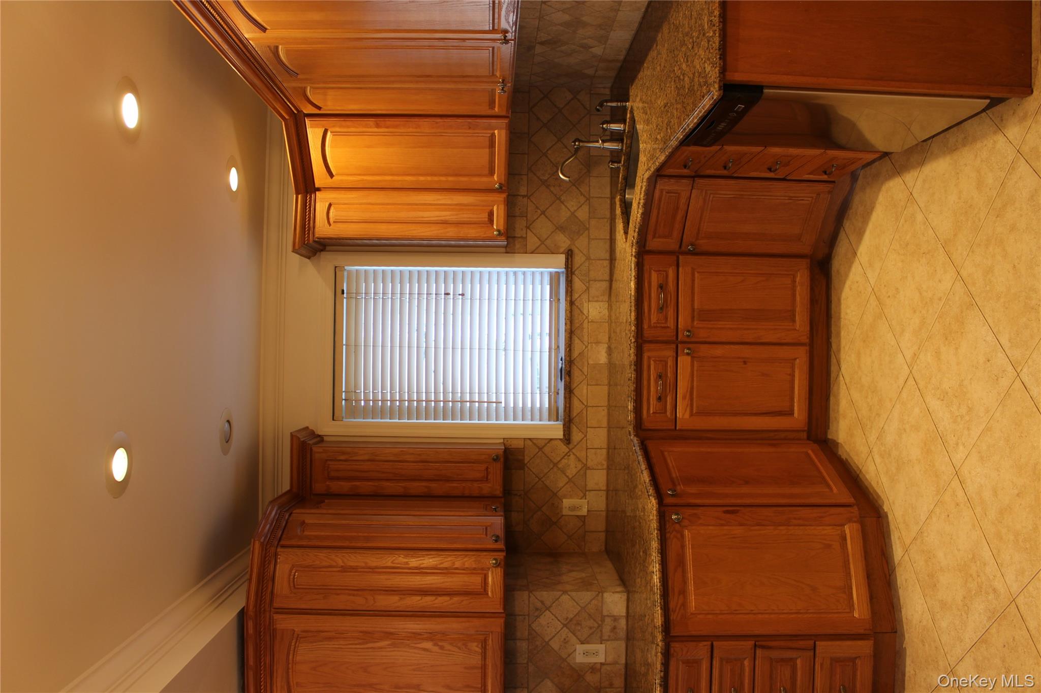 2973 Harding Avenue Bronx, NY 10465 - Photo 9 of 27 Kitchen featuring ornamental molding, brown cabinets, dark stone countertops, tasteful backsplash, and recessed lighting