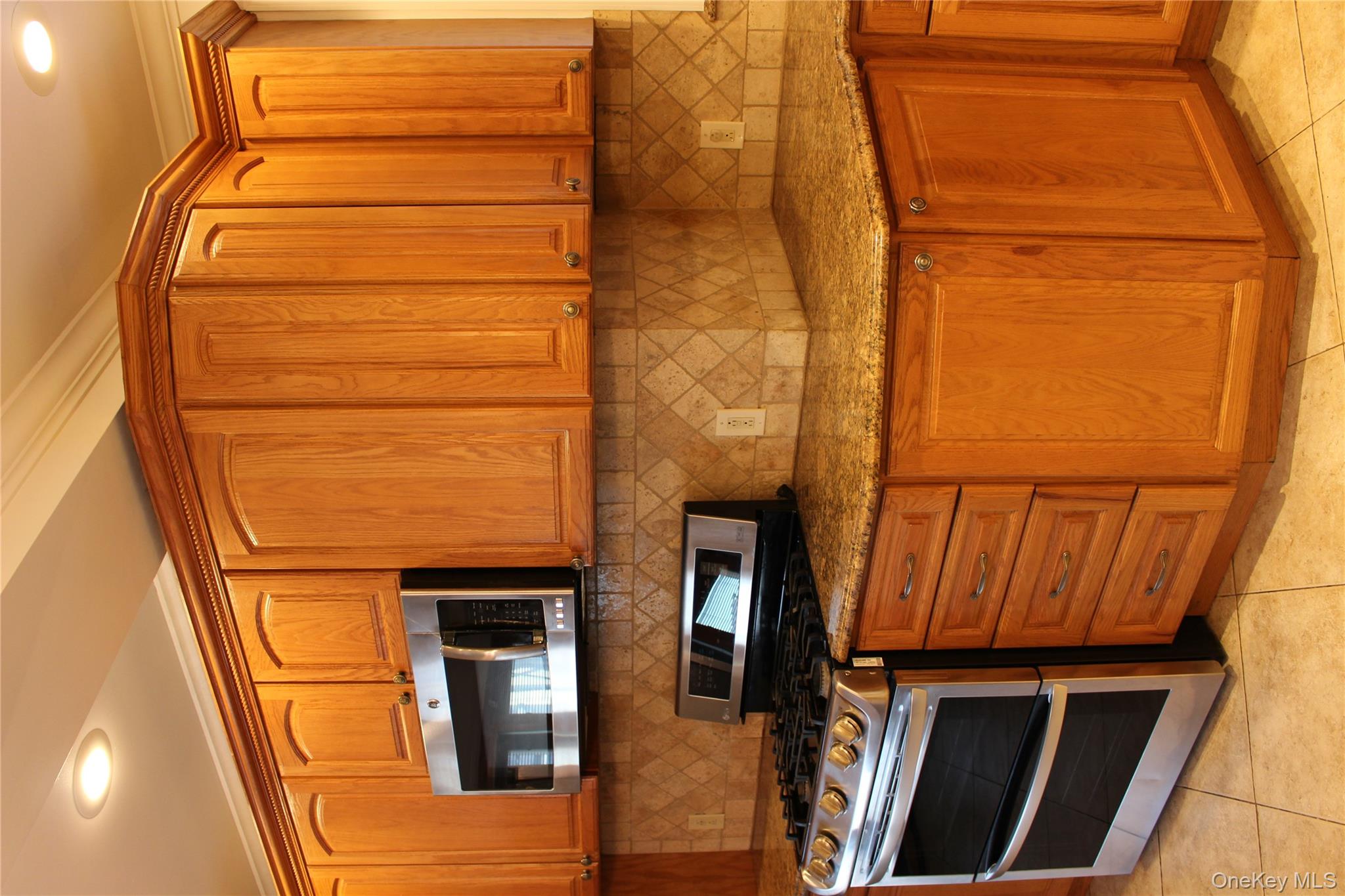 2973 Harding Avenue Bronx, NY 10465 - Photo 10 of 27 Kitchen with stainless steel stove, recessed lighting, brown cabinetry, tasteful backsplash, and light tile patterned floors