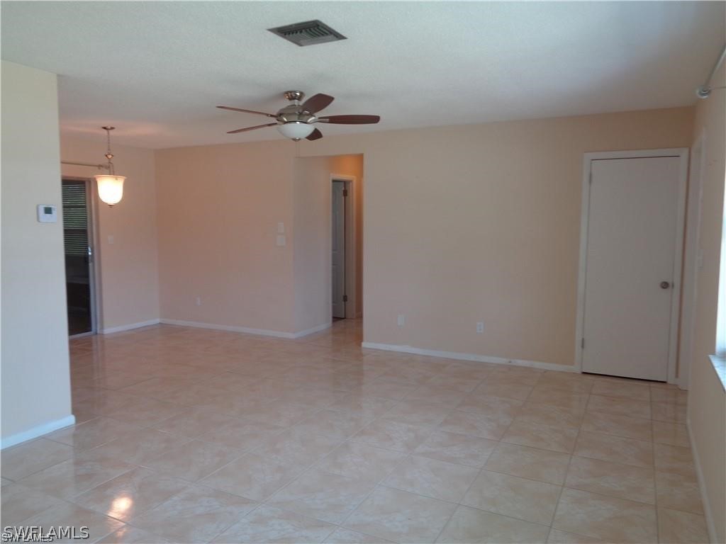 106 Jasmine Road West Lehigh Acres, FL 33936 - Photo 3 of 7 a view of a small space with a fan & a ceiling fan