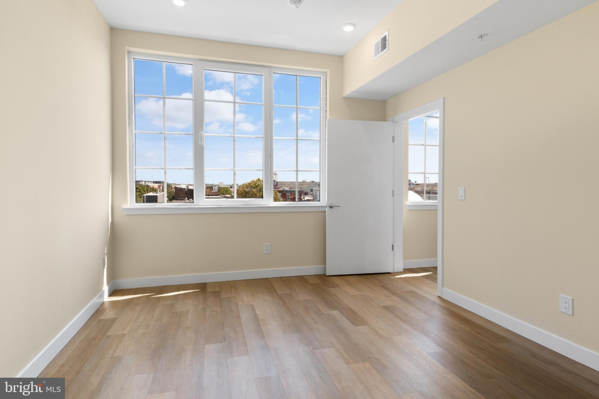 1701 South 4th Street, Unit 407 Philadelphia, PA 19148 - Photo 15 of 31 an empty room with wooden floor and windows