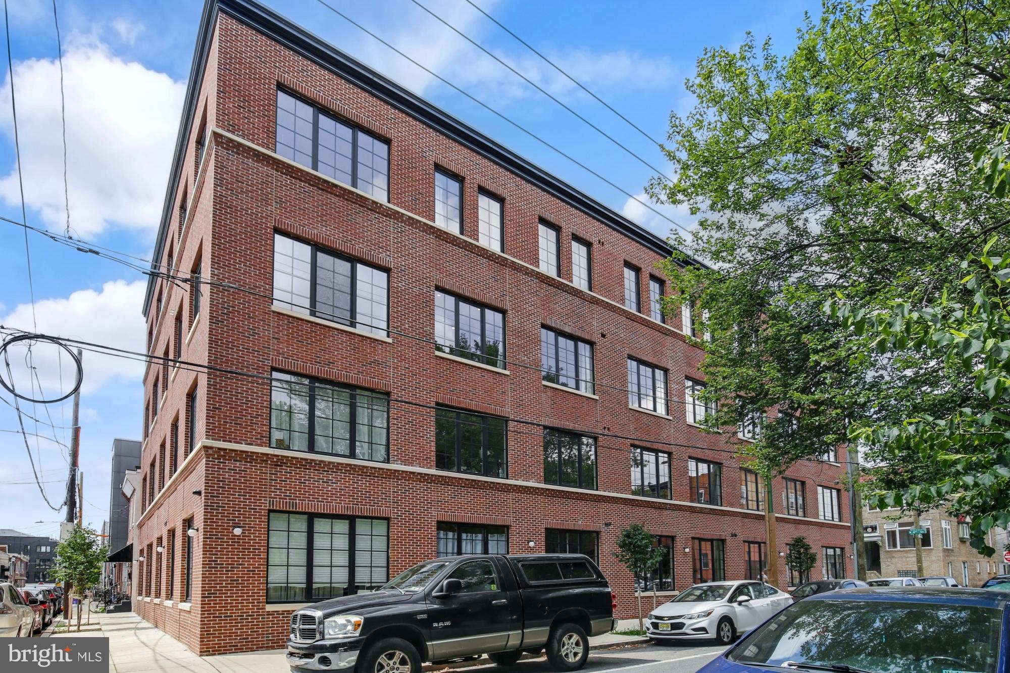 1701 South 4th Street, Unit 407 Philadelphia, PA 19148 - Photo 25 of 31 a front view of a building with lot of cars and trees