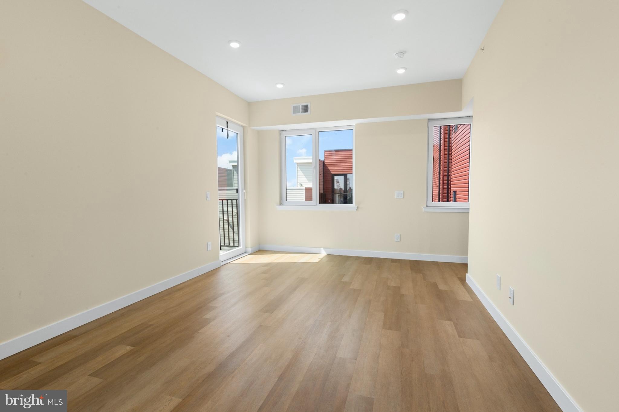 1701 South 4th Street, Unit 407 Philadelphia, PA 19148 - Photo 10 of 31 an empty room with wooden floor and windows