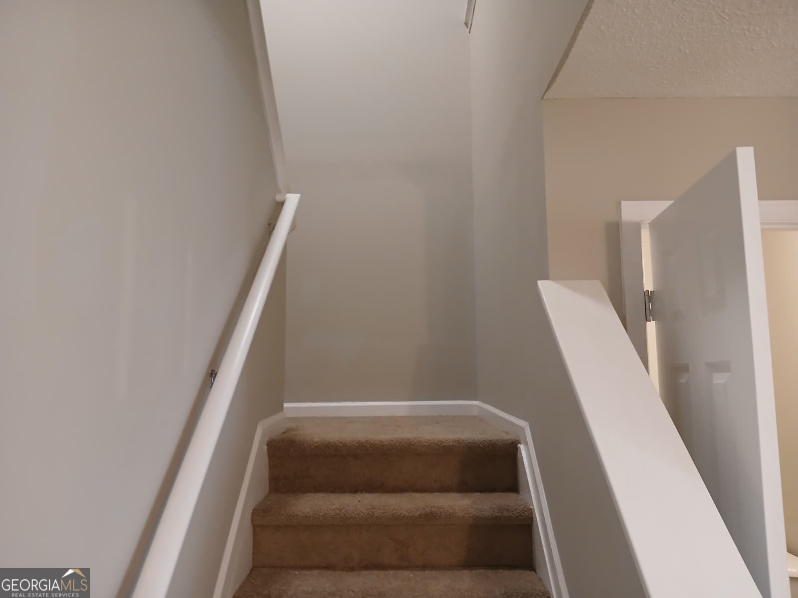 5190 Hanover Street Atlanta, GA 30349 - Photo 12 of 20 a view of staircase with white walls and white door
