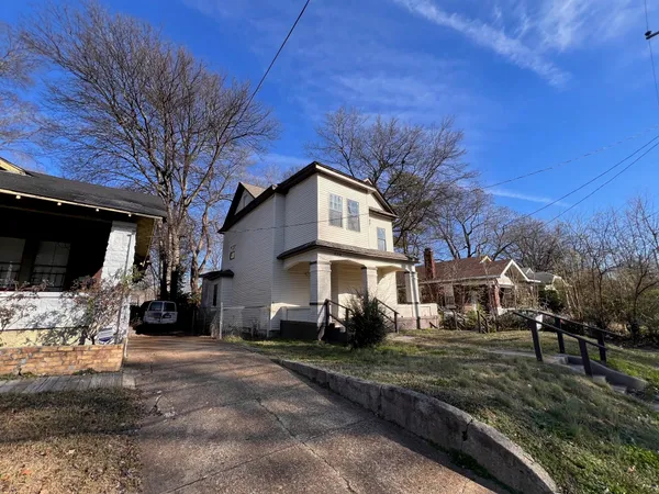 a view of a white house with a yard