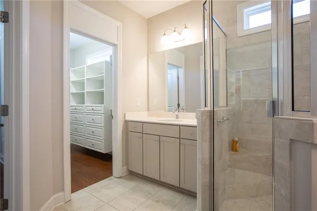a bathroom with a shower sink and mirror