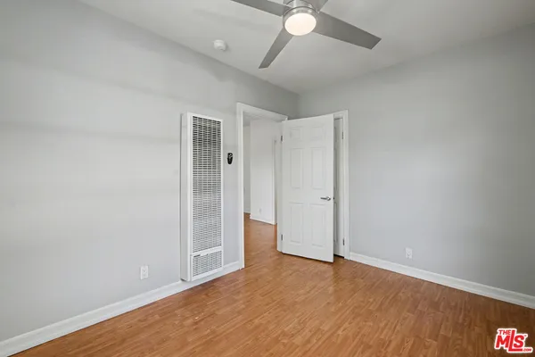 a view of an empty room with wooden floor