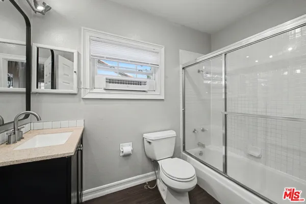 a bathroom with a shower sink vanity mirror and toilet
