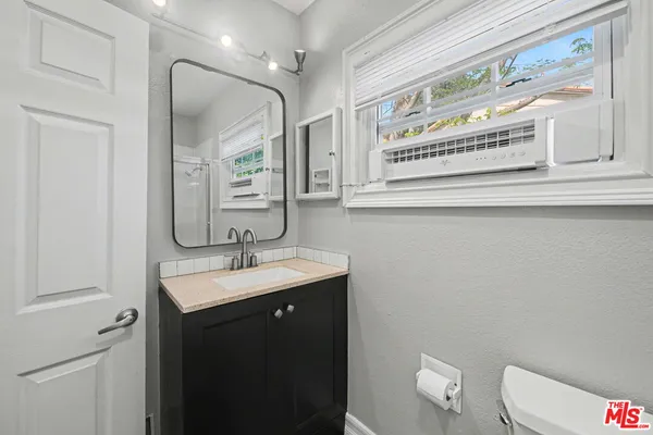 a bathroom with a toilet sink and mirror