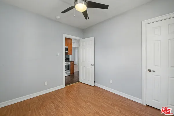 an empty room with closet and ceiling fan
