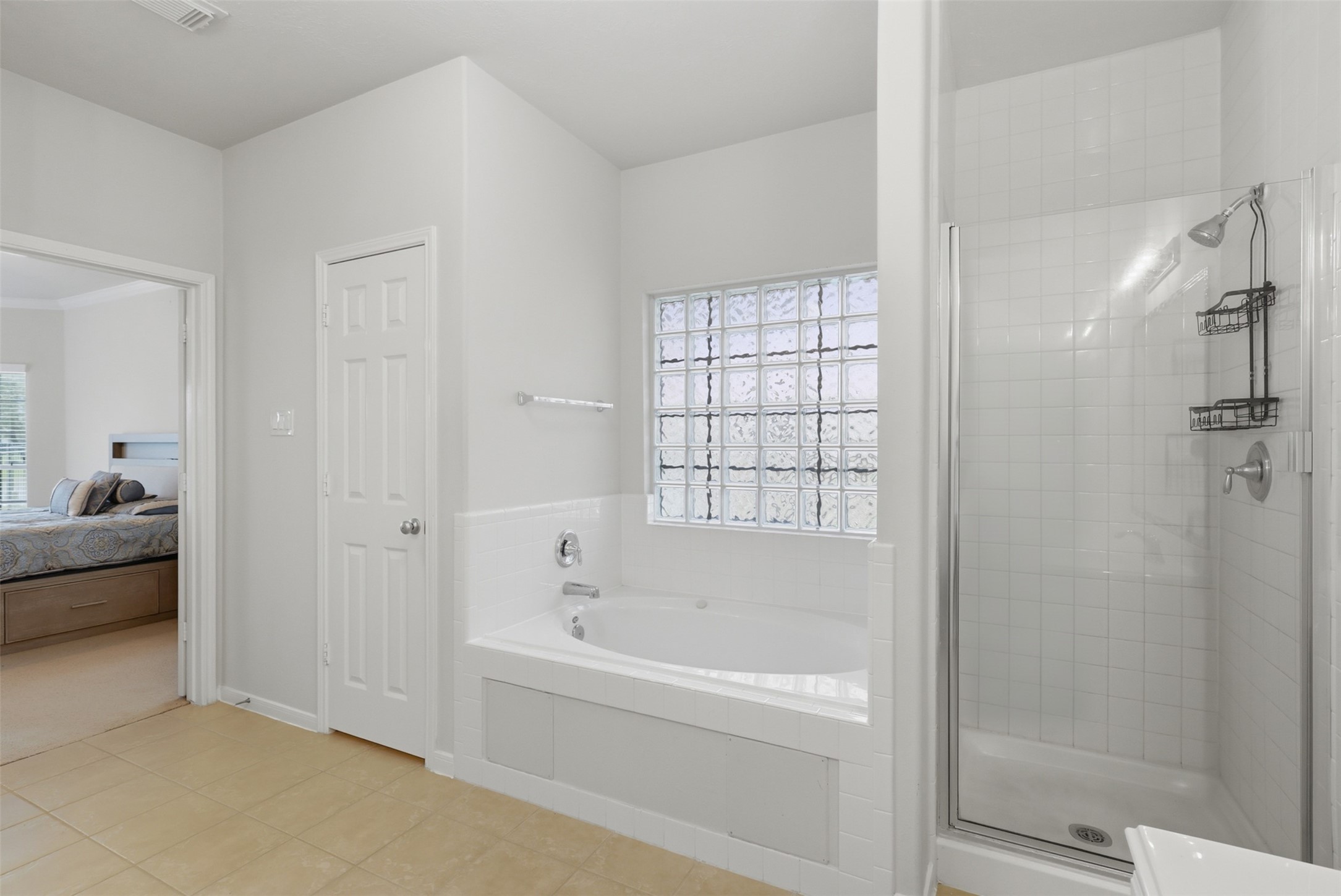 13806 Cove Landing Lane Rosharon, TX 77583 - Photo 23 of 44 A soaking tub, separate walk-in shower, and glass-block window complete the spacious primary bath.