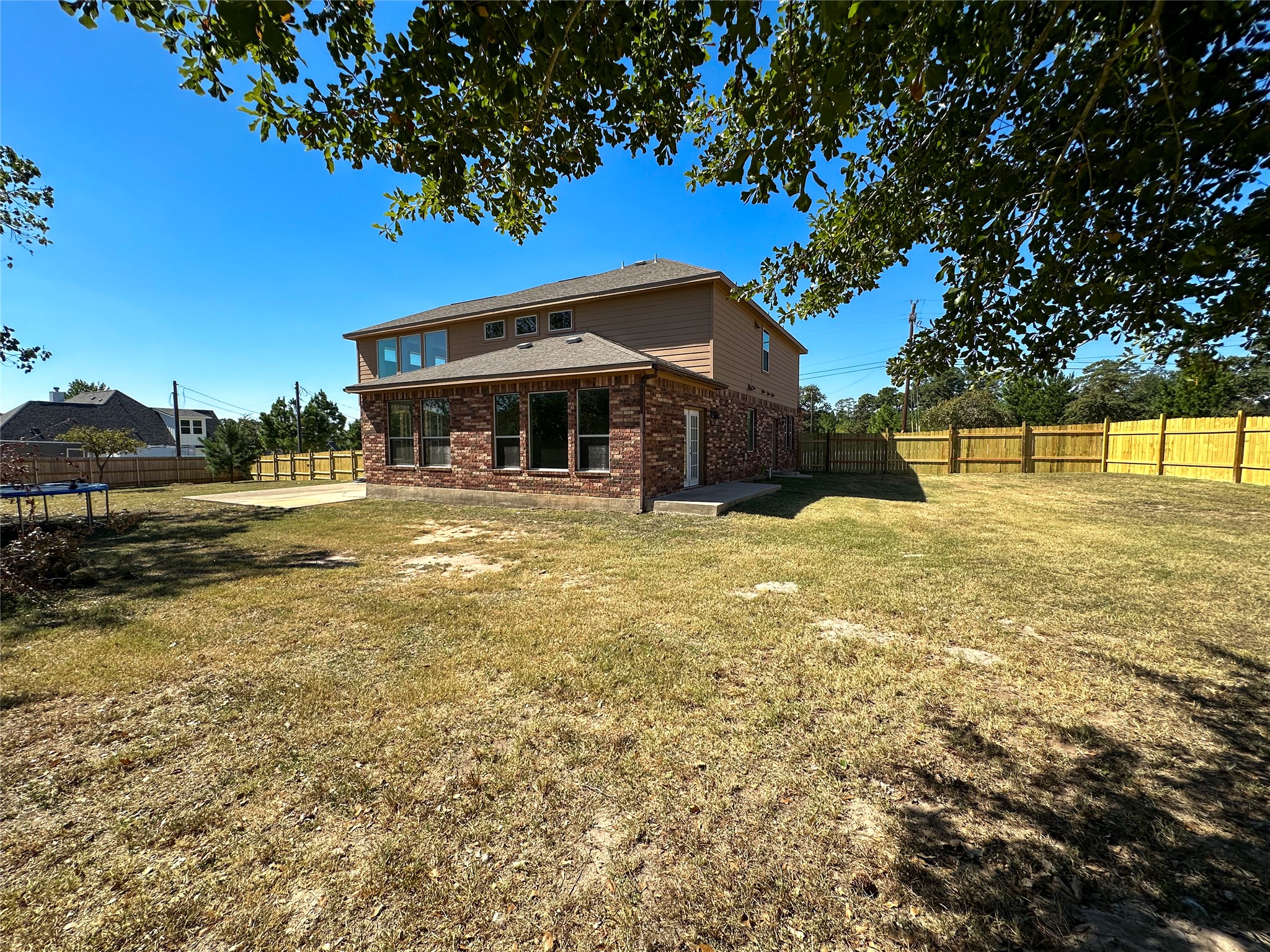 237 Cardinal Drive Paige, TX 78659 - Photo 29 of 37 Back of property featuring brick siding, a fenced backyard, and a patio area