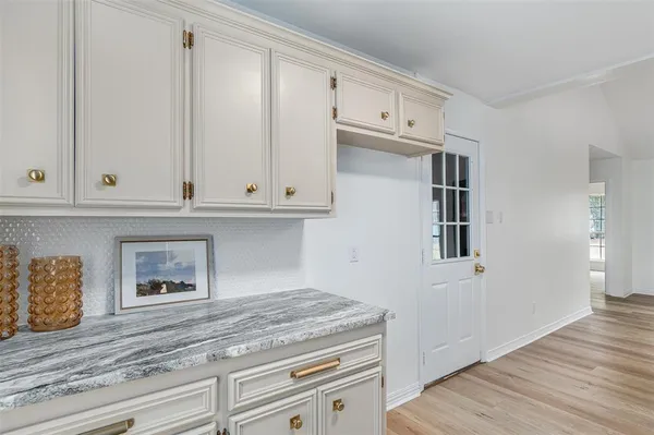 a kitchen with granite countertop white cabinets and white appliances