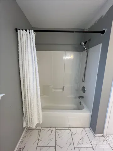 a bathroom with a shower and a bath tub