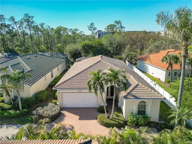 a front view of a house with a yard and potted plants