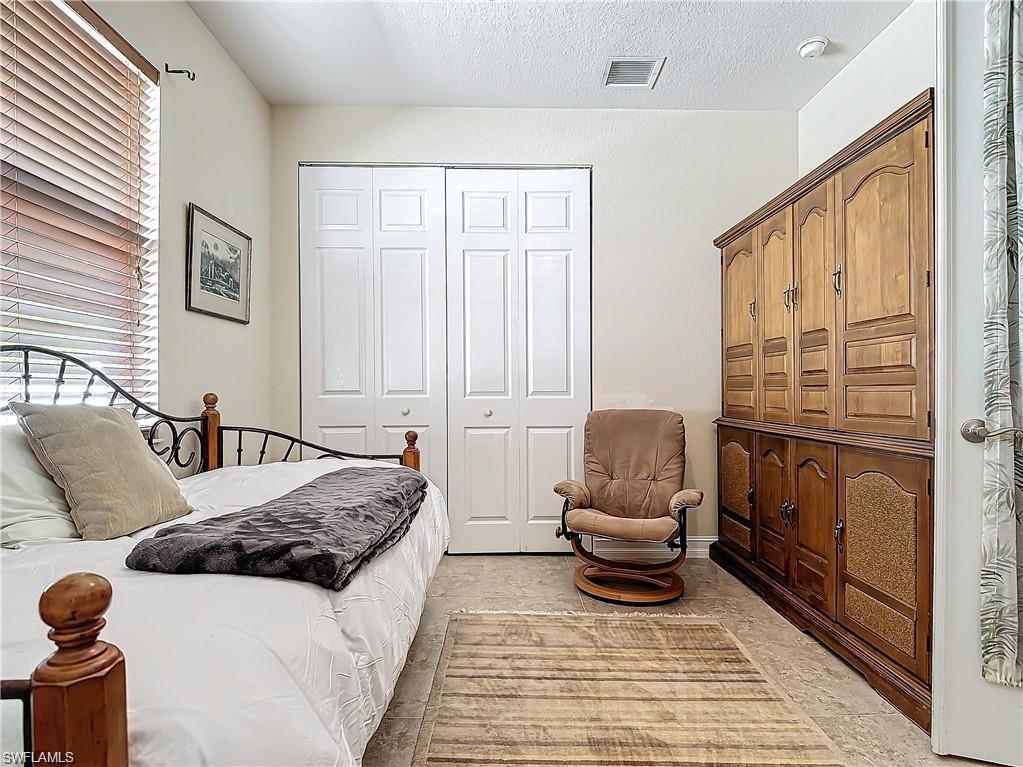 1680 Sanctuary Pointe Court Naples, FL 34110 - Photo 13 of 20 a bedroom with a bed and wooden floor