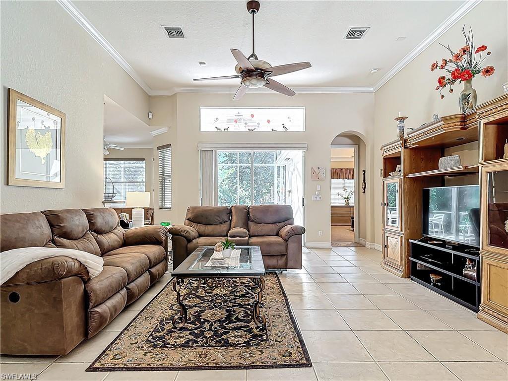 1680 Sanctuary Pointe Court Naples, FL 34110 - Photo 6 of 20 a living room with furniture a flat screen tv and a window