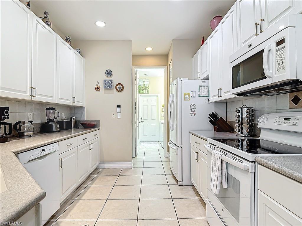 1680 Sanctuary Pointe Court Naples, FL 34110 - Photo 7 of 20 a kitchen with stainless steel appliances granite countertop a sink and a stove