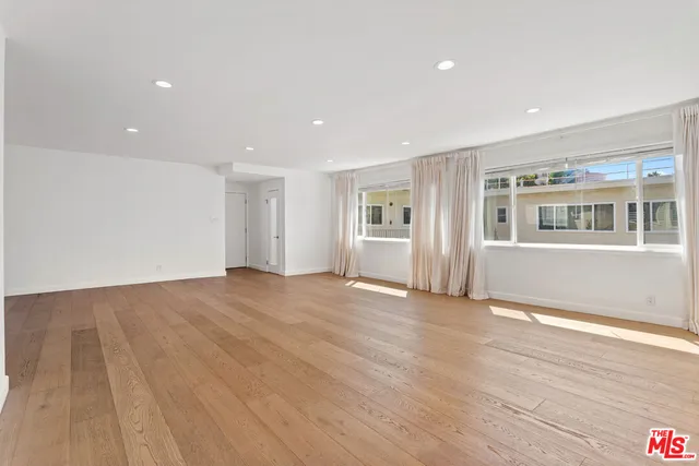 a view of a livingroom with wooden floor and windows