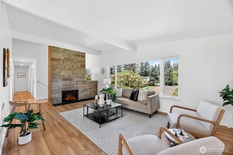 a living room with furniture fireplace and a large window