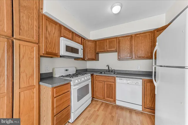 a kitchen with stainless steel appliances granite countertop a refrigerator a stove and a sink