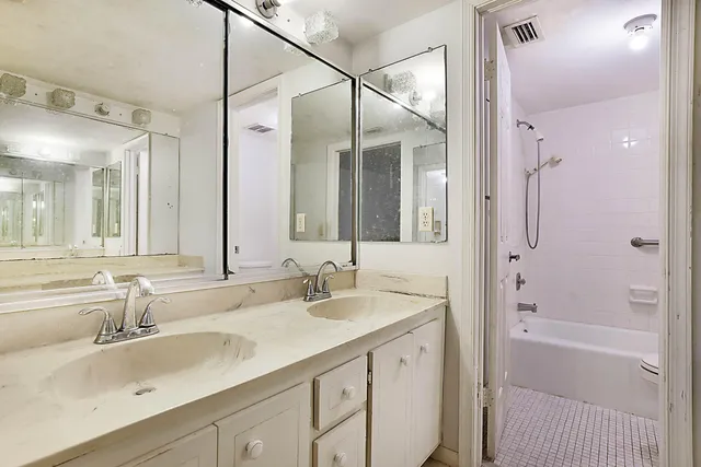 a bathroom with a granite countertop sink mirror and a bath tub