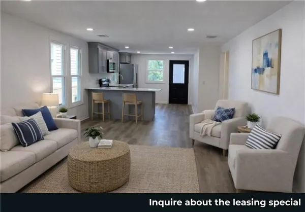 a living room with furniture and a view of kitchen