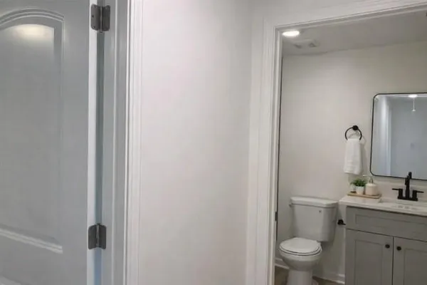 a bathroom with a toilet a sink and mirror