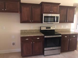 5760 Marigold Loop Crestview, FL 32539 - Photo 15 of 31 a kitchen with granite countertop wood cabinets and stainless steel appliances