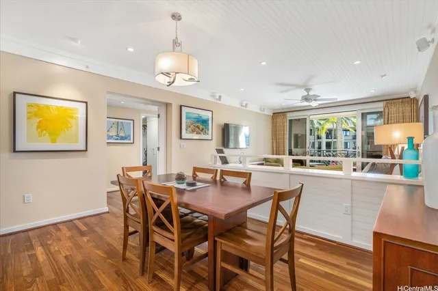 a dining room with wooden floor and a chandelier