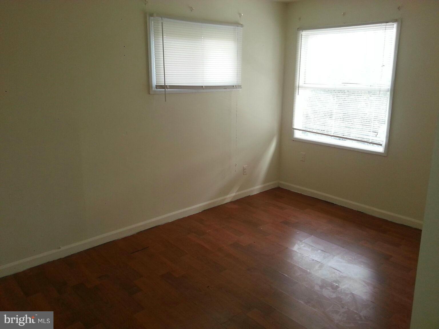 12130 Bluhill Road Silver Spring, MD 20902 - Photo 3 of 6 an empty room with wooden floor and windows