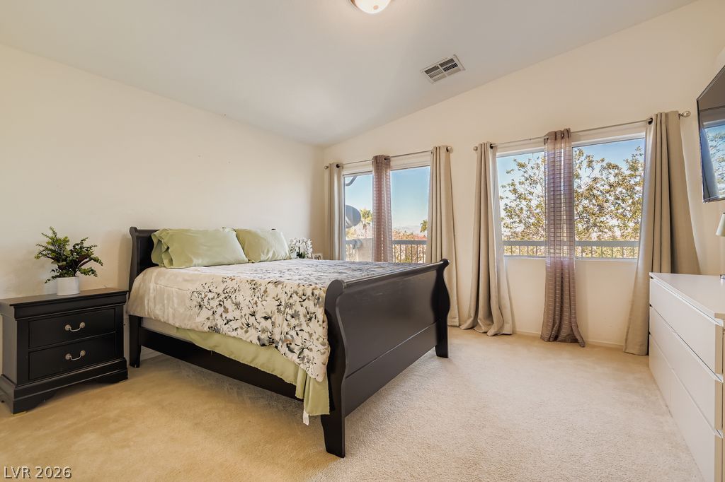 1586 Rusty Ridge Lane Henderson, NV 89002 - Photo 9 of 11 Natural light floods this inviting bedroom with vaulted ceilings and expansive outdoor views.