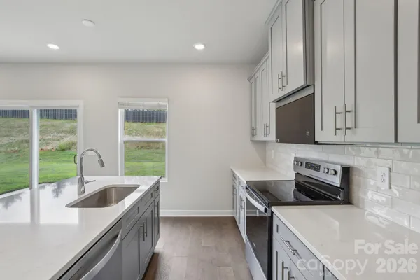 a kitchen that has a sink and a stove top oven