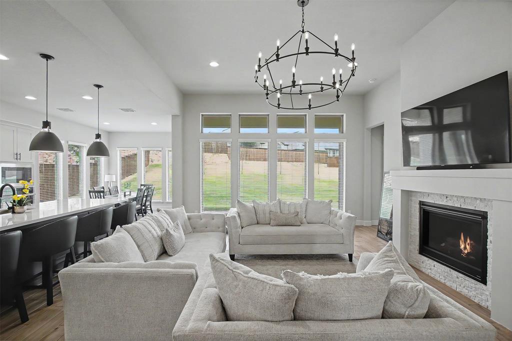 116 Derrett Lane Rhome, TX 76078 - Photo 5 of 30 a living room with furniture a chandelier and a fireplace