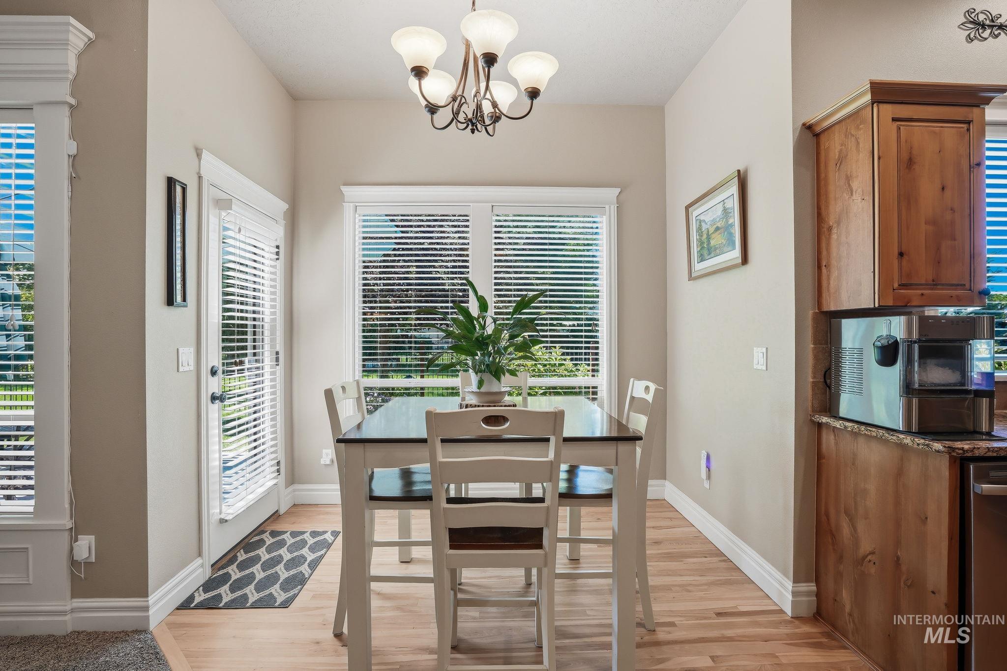 3969 North Hollymount Way Meridian, ID 83646 - Photo 16 of 47 Dining area with light wood-finish flooring, a contemporary chandelier, and ample natural light from multiple windows