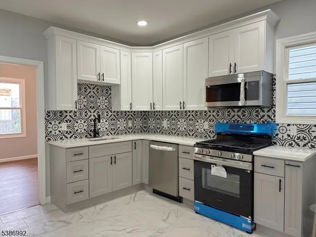 a kitchen with cabinets stainless steel appliances and wooden floor