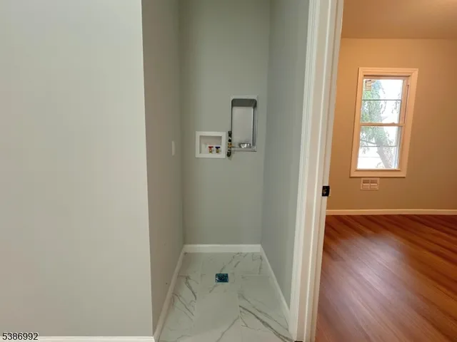 an empty room with a window and wooden floor